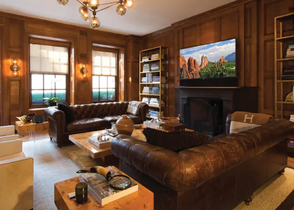 Wood-paneled living room with a wall-mounted television